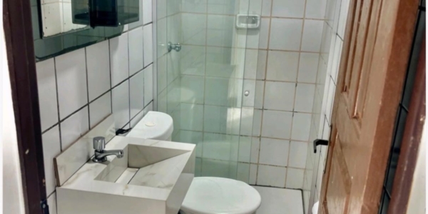 Banheiro moderno com box e acabamento clean na casa em Salinas