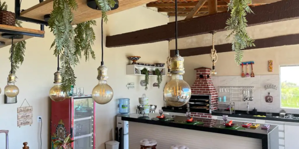 Área gourmet de alto padrão em Salinas com churrasqueira e bancada em granito.