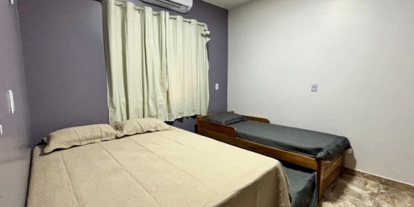 Suíte master com ar-condicionado e cama de casal confortável.