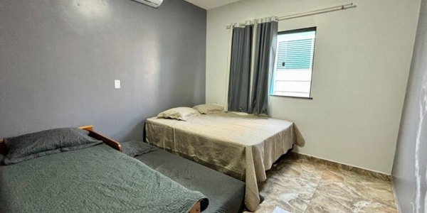 Terceira suíte configurada com camas de solteiro para grupos.