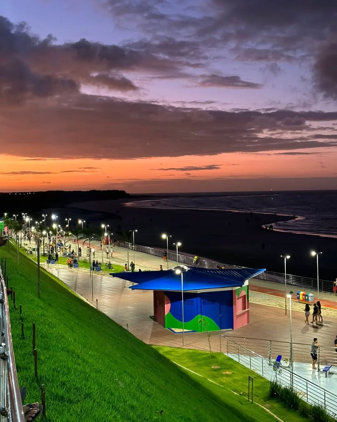 Roteiros em Salinas: Guia Completo da Orla do Maçarico e Vida Noturna Roteiros em Salinas apresentando a Orla do Maçarico com seu calçadão estruturado, luminárias modernas e vista para o encontro das águas ao entardecer.