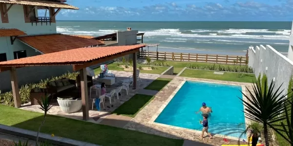 Casa pé na areia em Salinas com 4 suítes e piscina privativa Fachada de casa para alugar em Salinas pé na areia na Praia do Atalaia, com 4 suítes climatizadas e ampla área de lazer.